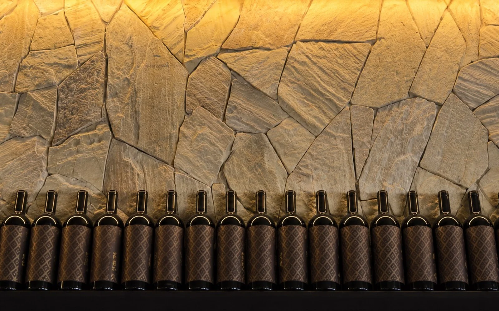 Mur de bouteilles éclairé utilisé comme photographie d’ambiance du site restaurant